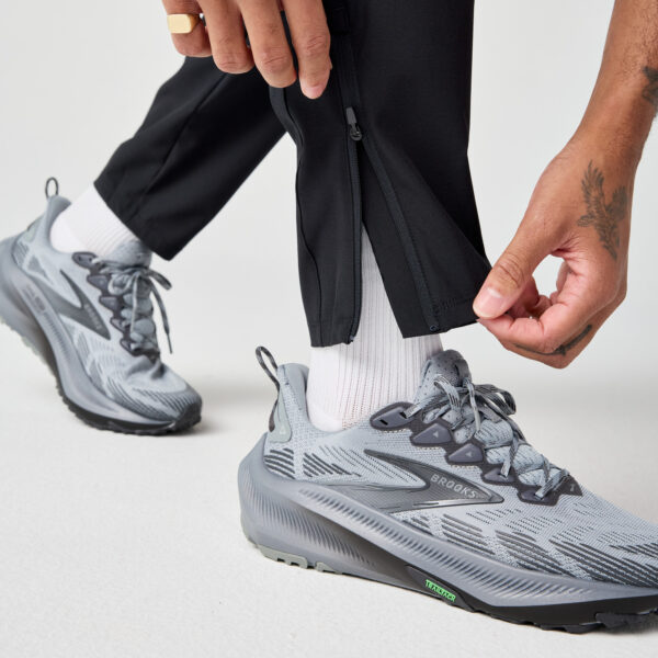 Brooks Men's Canopy Pant -juoksuhousujen vetoketju lahkeensuussa helpottaa pukemista.