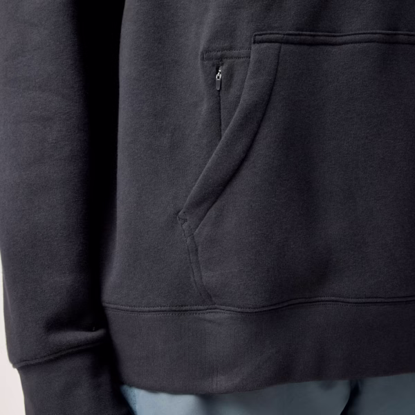 Brooks Reset Hoodie -hupparin kengurutasku, jonka sisällä on pieni vetoketjullinen säilytystasku.