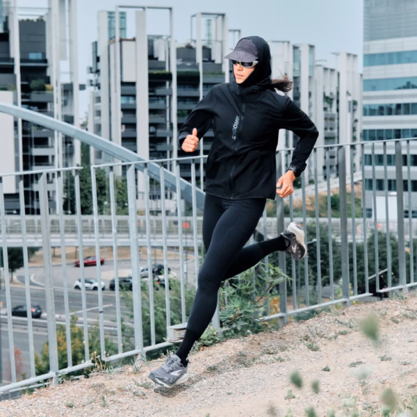 Juoksija käyttää Brooks Women's Canopy Jacket -juoksutakkia tuulisella ja kevyesti sateisella lenkillä.