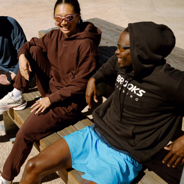 Henkilö käyttää Brooks Reset Hoodie -fleecehupparia lämmittelyssä, palautumisessa tai rennossa vapaa-ajassa.