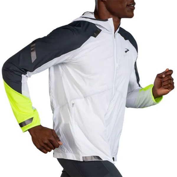 Juoksija käyttää Brooks Run Visible Convertible Jacket -juoksutakkia pimeällä ja sateisella lenkillä.