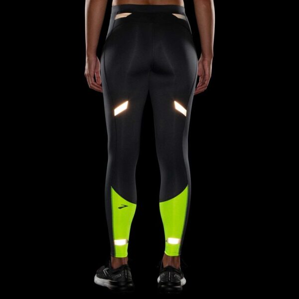 Juoksija käyttää Brooks Women's Run Visible Thermal Tight -juoksutrikoita pimeällä lenkillä.